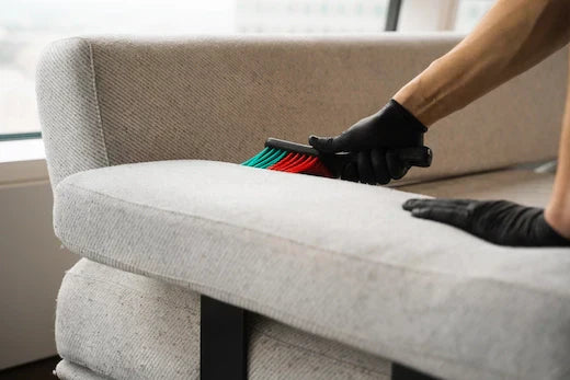 persona lavando funda de sofá muy sucia